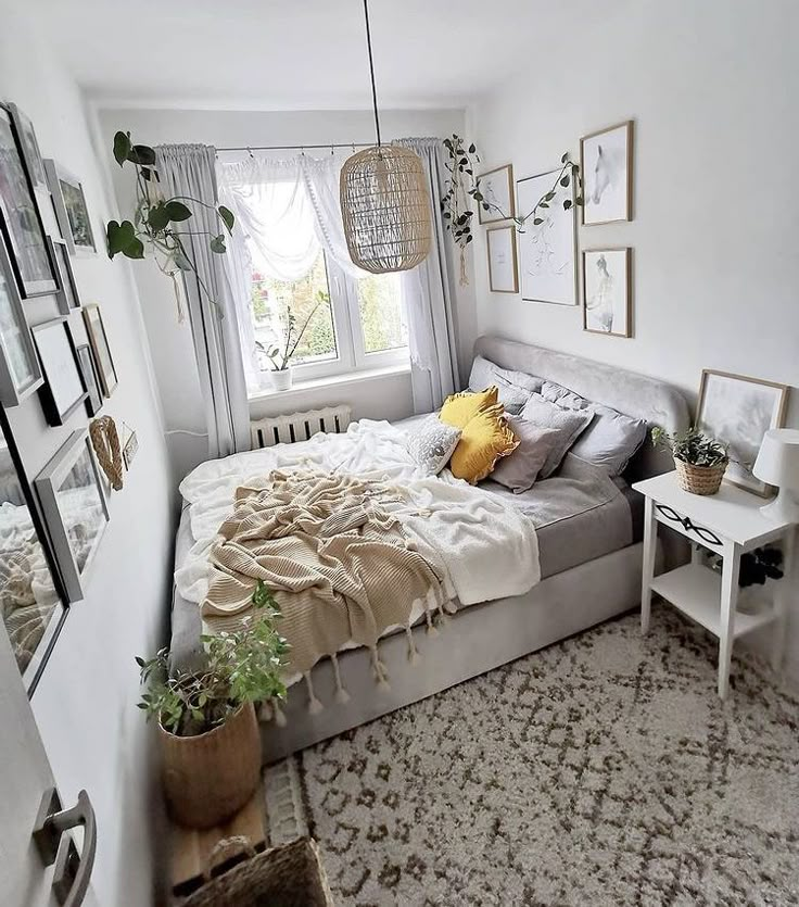 a bed sitting in a bedroom under a window next to a white table and chair