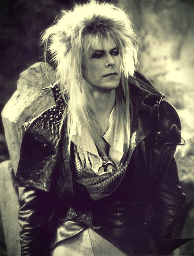 an old black and white photo of a woman with long blonde hair wearing leather clothes