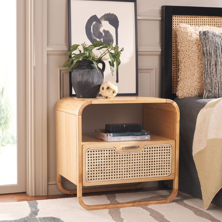 a wooden side table with a radio on it next to a bed in a room