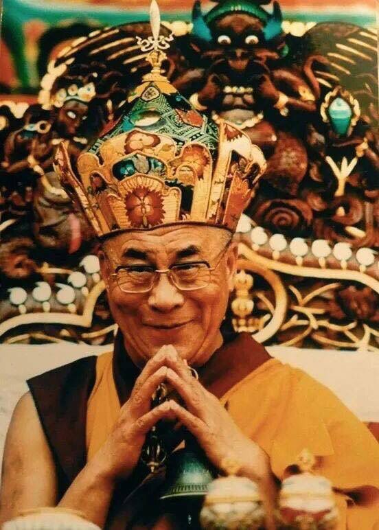 an older man wearing a crown and holding a bell in his hands while sitting down