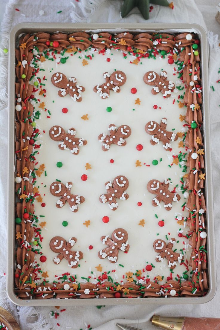 a sheet cake with frosting and decorated gingerbreads