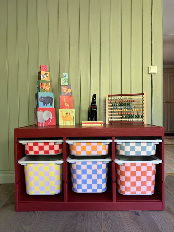 colorful baskets are lined up on a red shelf