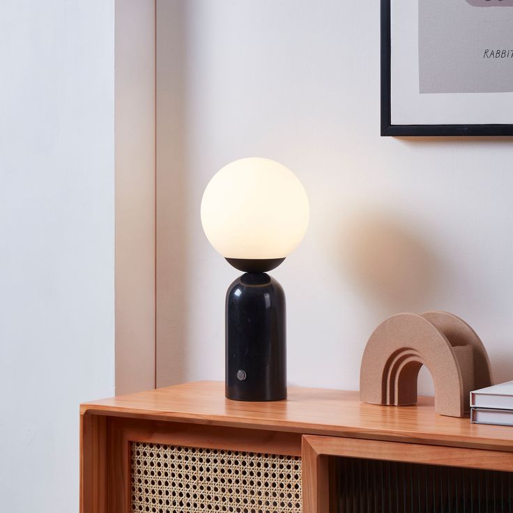 a black lamp sitting on top of a wooden table