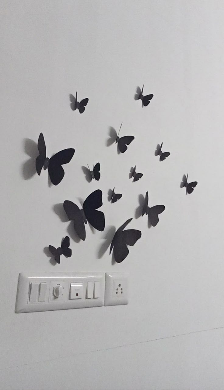 a bunch of butterflies are flying in the air next to an electrical outlet and power strip