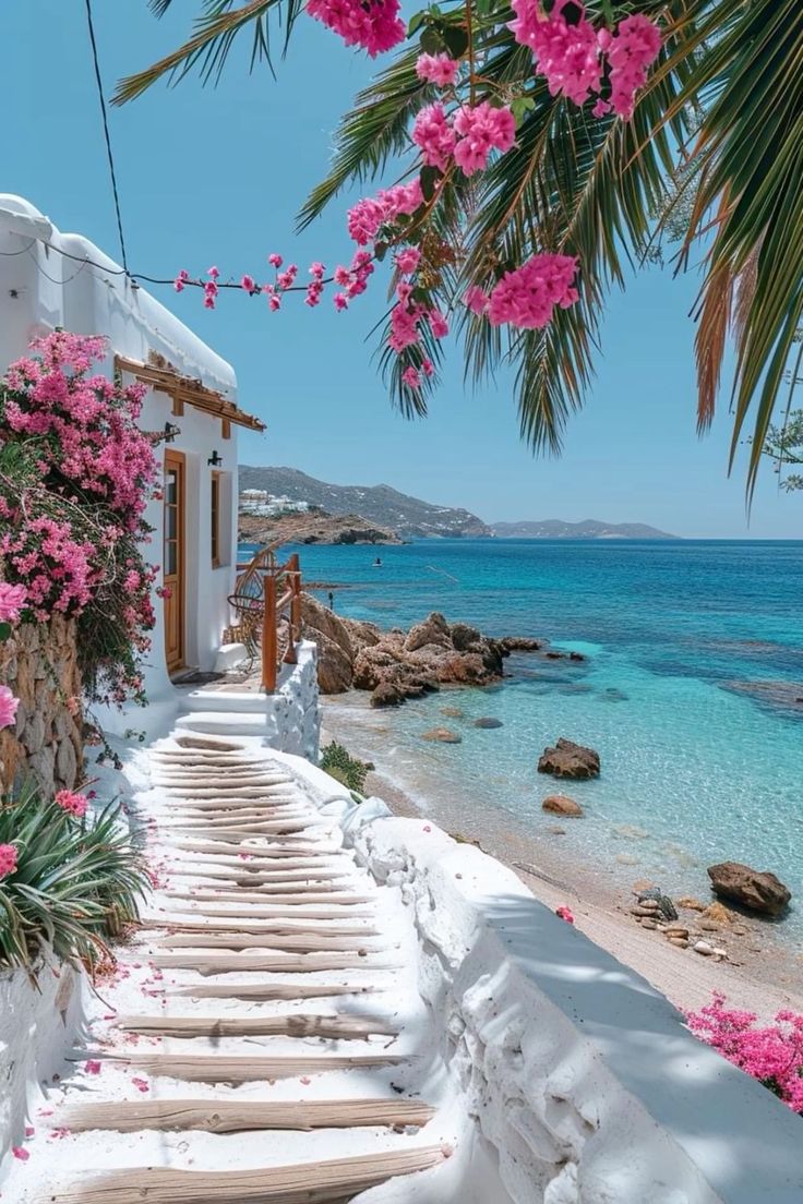 stairs leading to the beach with pink flowers on them