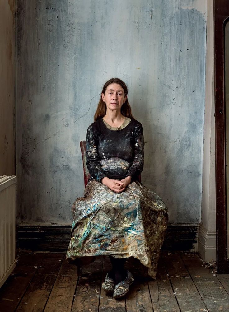 a woman is sitting in a chair with her hands on her stomach and looking up