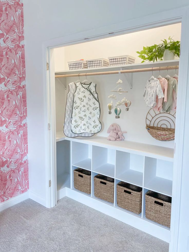 the closet is filled with baby's clothing and toys, including baskets for storage