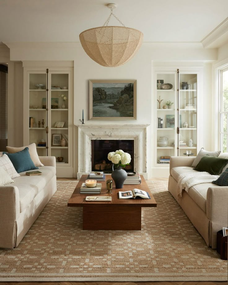 a living room with two couches and a coffee table in front of a fireplace