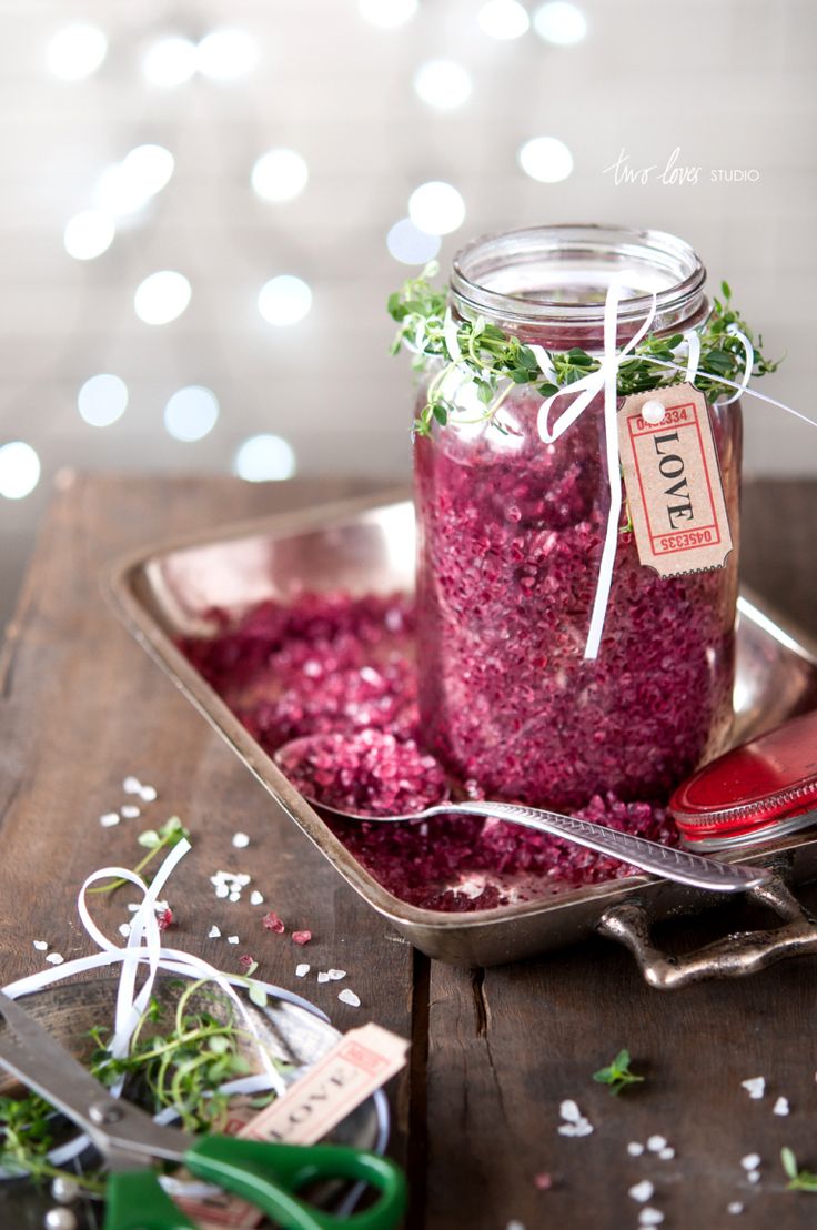 a jar filled with red food sitting on top of a wooden table