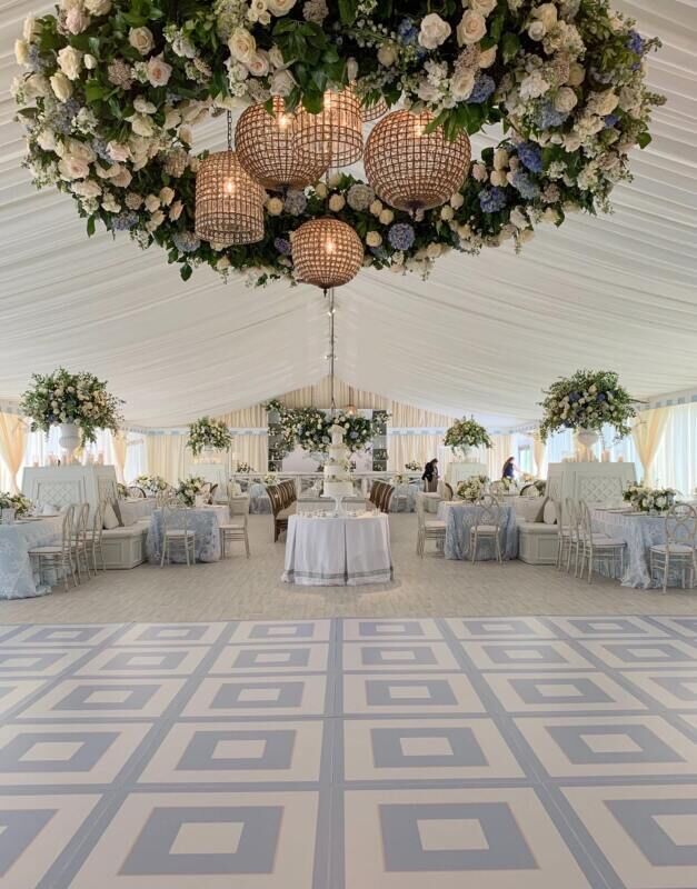 a large room with tables, chairs and chandeliers on the ceiling is decorated with flowers