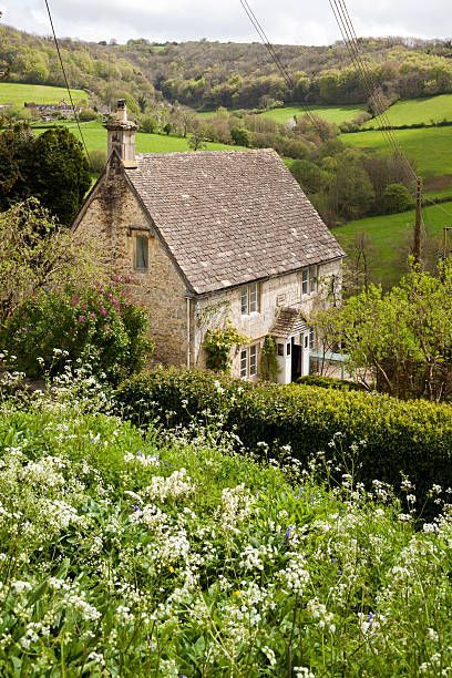 an old stone house surrounded by lush green hills