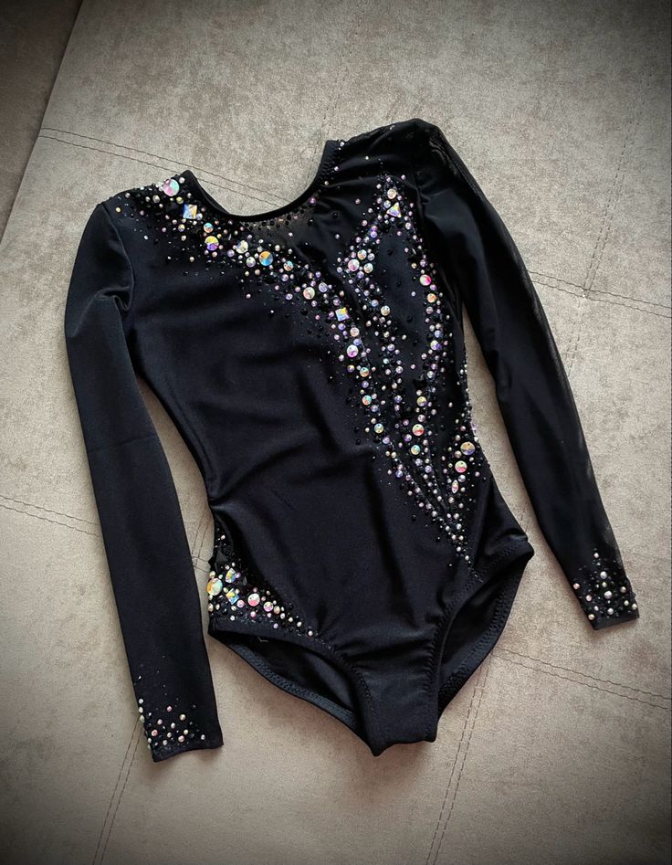 a black leotard with colorful sequins on the back and long sleeves