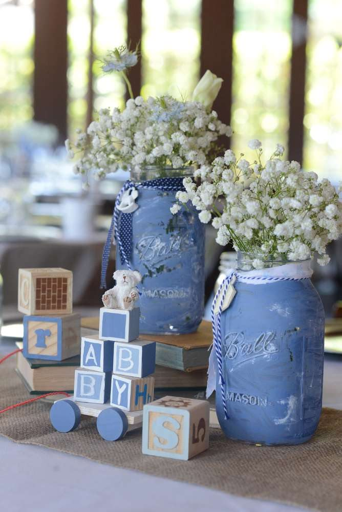 two blue mason jars filled with baby's breath flowers and blocks on a table