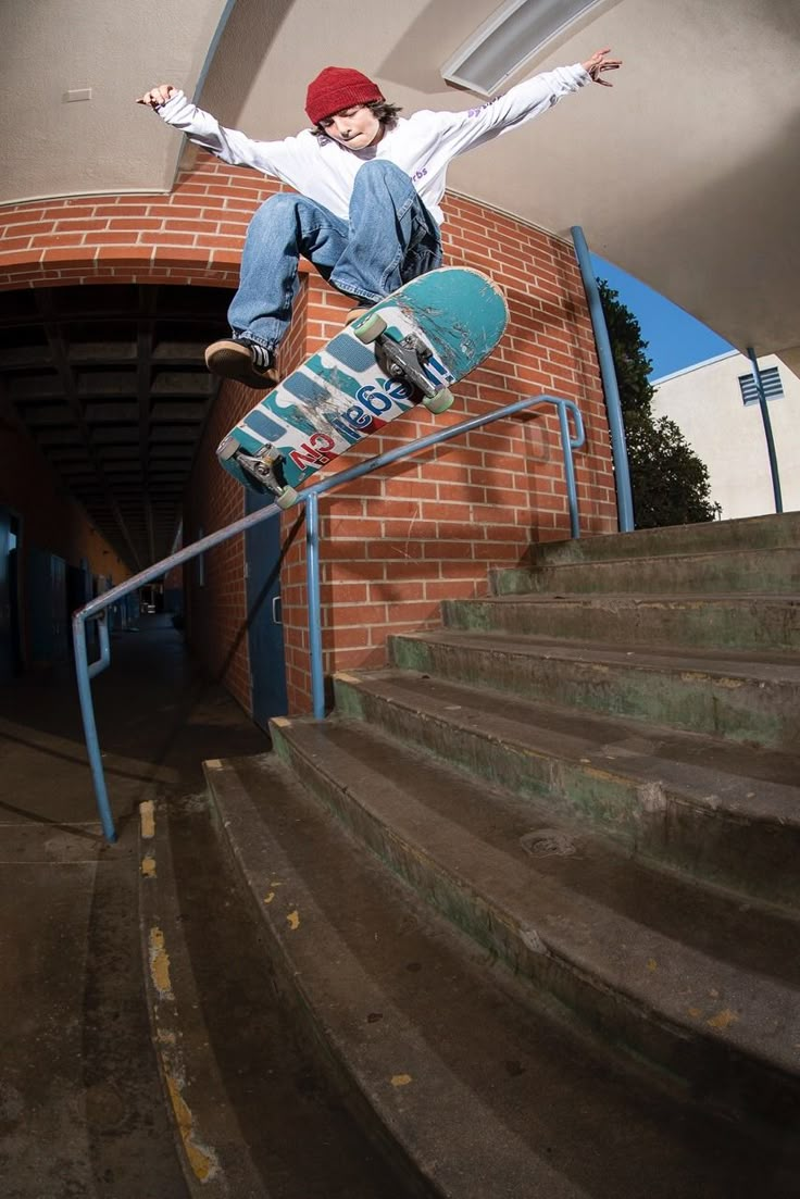 a man riding a skateboard up the side of a set of stairs next to a brick wall