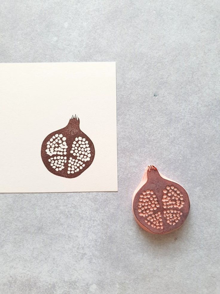 a pomegranate stamp sitting on top of a piece of paper next to a card