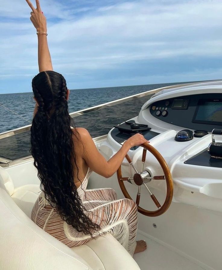 a woman sitting on the back of a boat waving