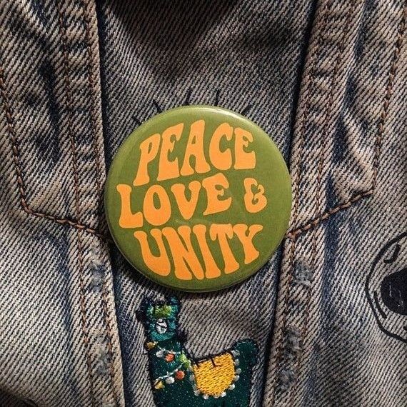 a button that says peace love and unty on the back of a jean jacket