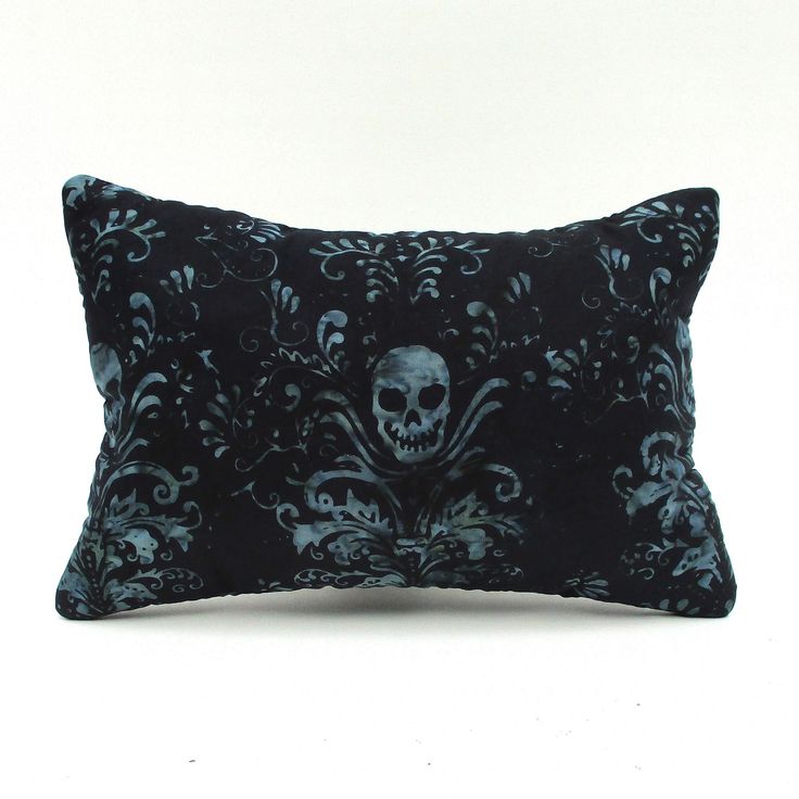 a black and blue pillow with a skull on it