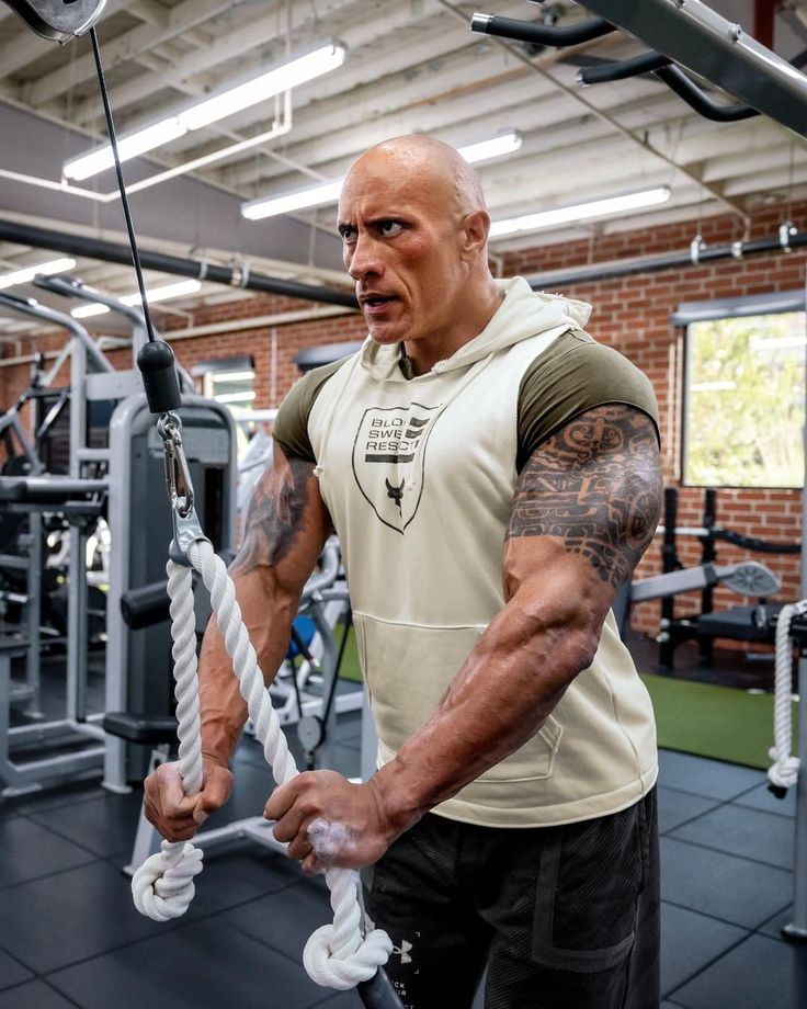 a man in a gym holding onto ropes