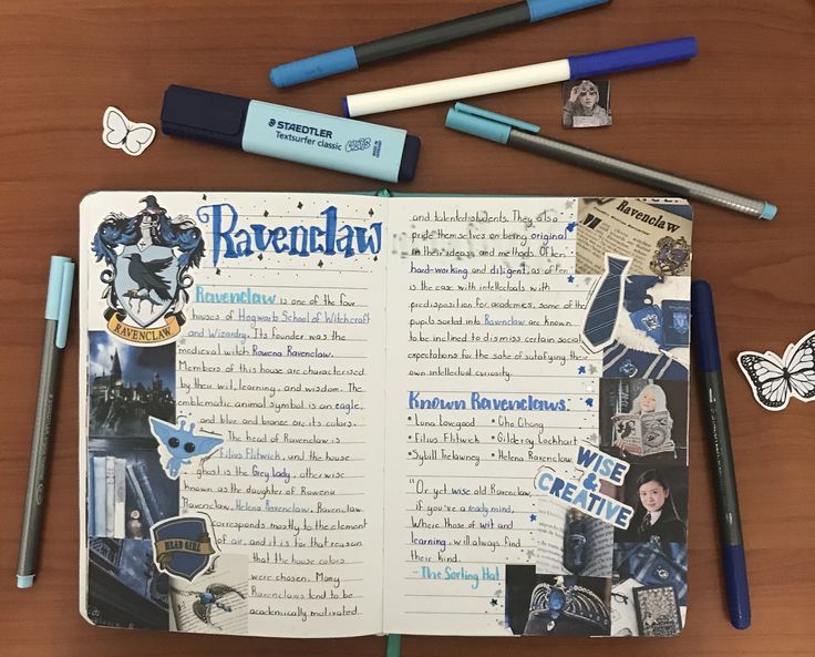 an open notebook with harry potter stickers and markers on it, next to some pens