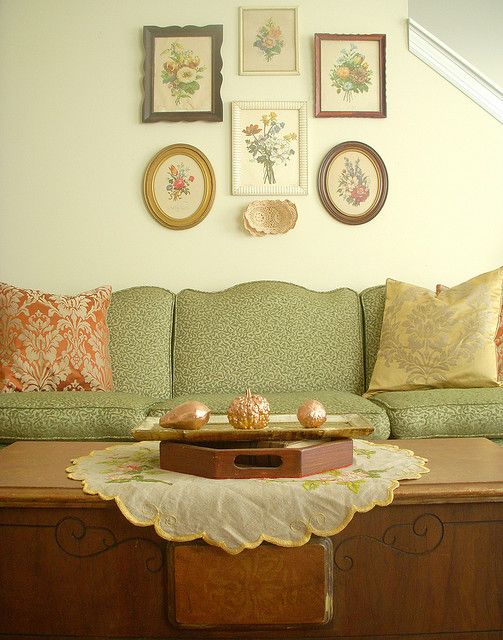 a living room filled with lots of furniture and pictures on the wall above it's coffee table