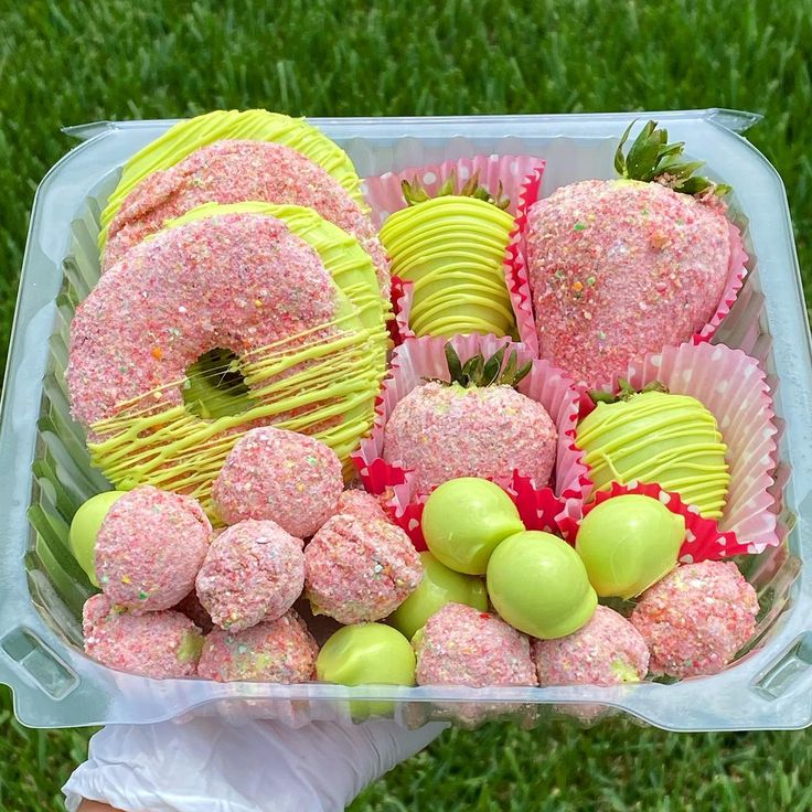 a plastic container filled with lots of candy covered donuts