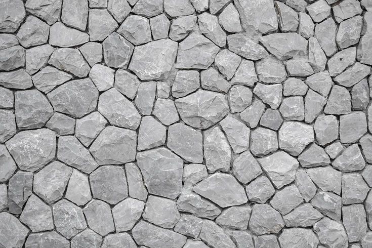 a stone wall that looks like it has been made out of rocks and is grey