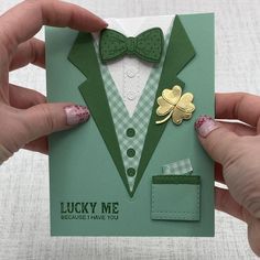 a person holding up a card with a green suit and bow tie on it