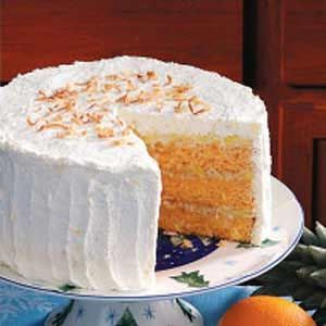 there is a cake with white frosting and oranges on the plate next to it