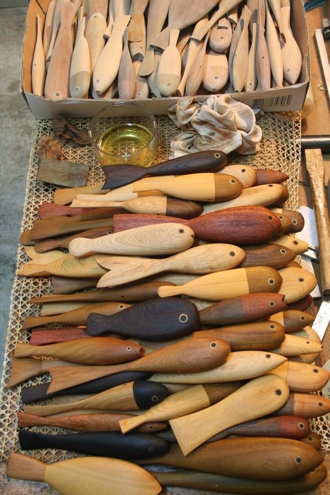 many wooden spoons are lined up on a table