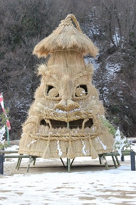 a tiki house made out of straw with a face on it's side