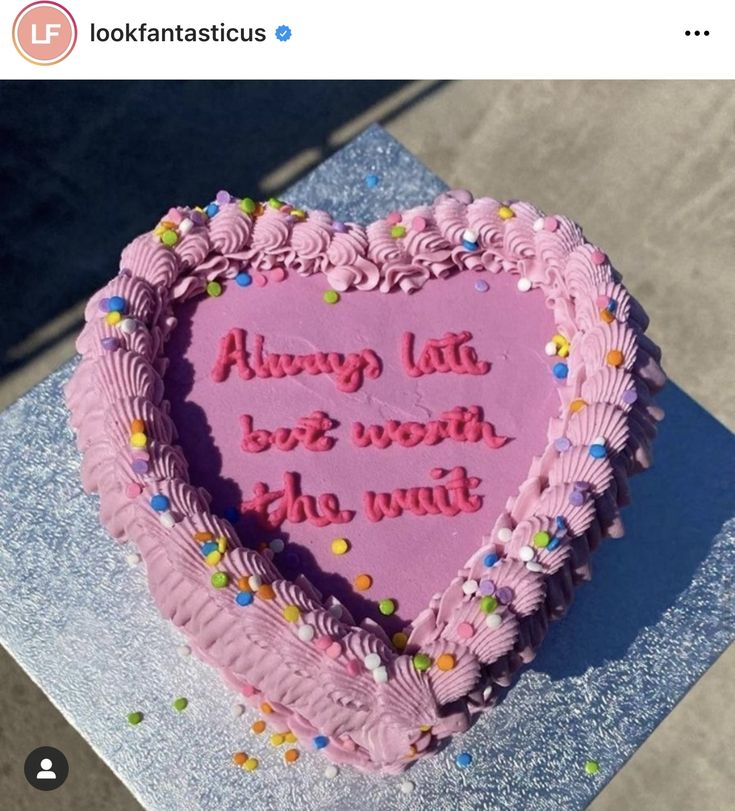 a pink heart shaped cake with sprinkles on it that says always late, be worth the wait