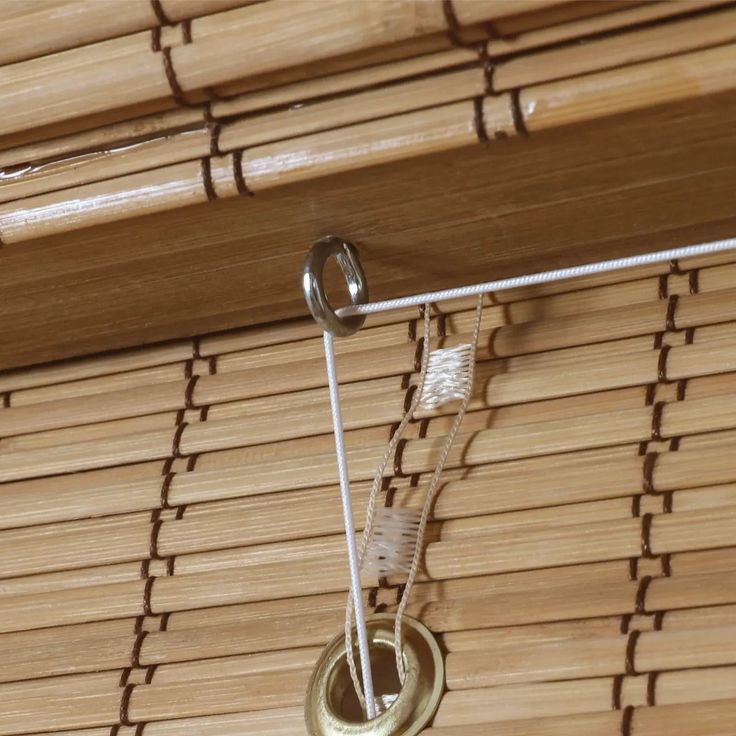 a close up of a bamboo blinds with some metal rings hanging from the top and bottom