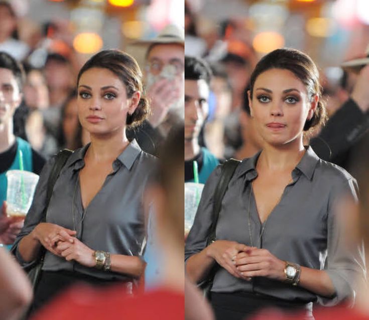 a woman standing in front of a crowd with her hand on her hip and looking at the camera