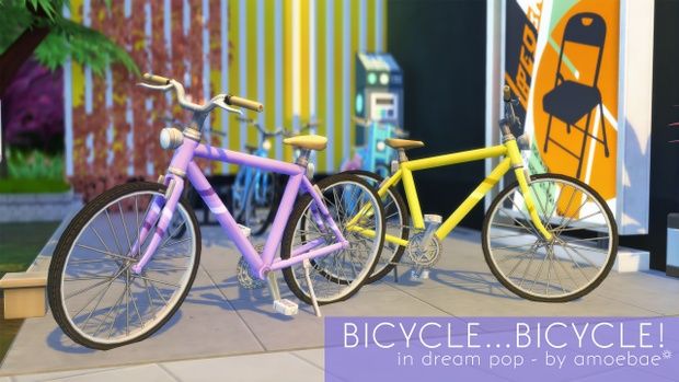 two colorful bikes parked next to each other on a sidewalk in front of a building