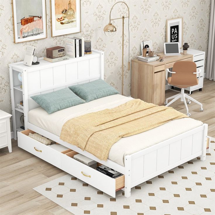 a white bed with drawers underneath it in a bedroom next to a desk and chair