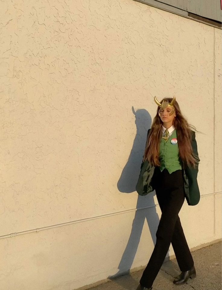 a woman with horns is walking by a building