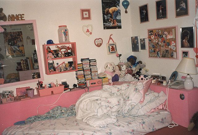 a bedroom with many pictures on the wall and stuffed animals all over the room,