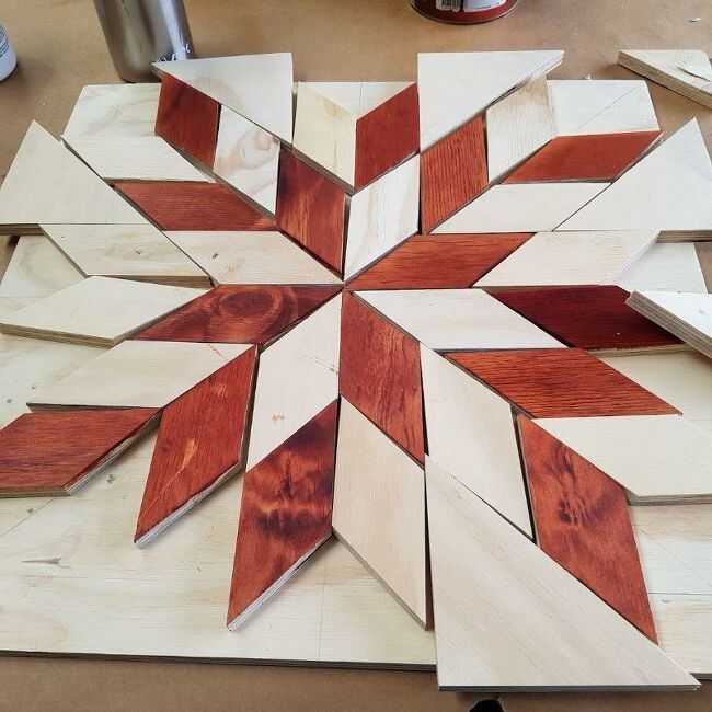 a wooden snowflake sitting on top of a table next to other wood pieces