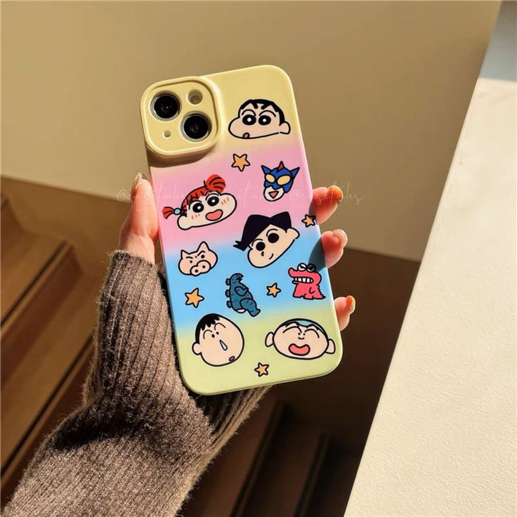 a person holding up a phone case with cartoon characters on it