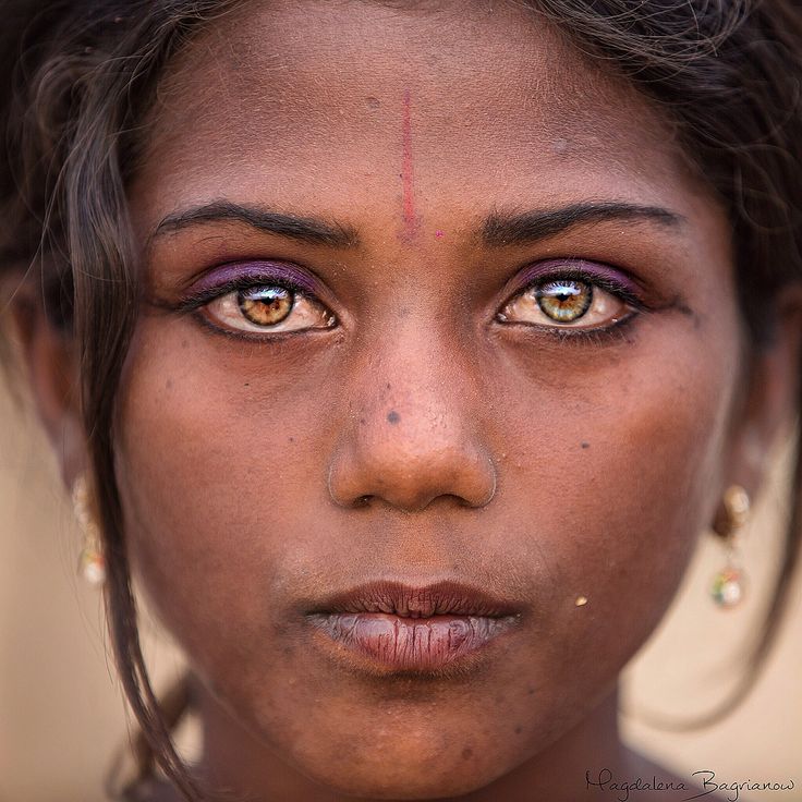 a close up of a woman's face with blue eyes