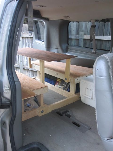 the back end of a van with bookshelves and shelves in the trunk area