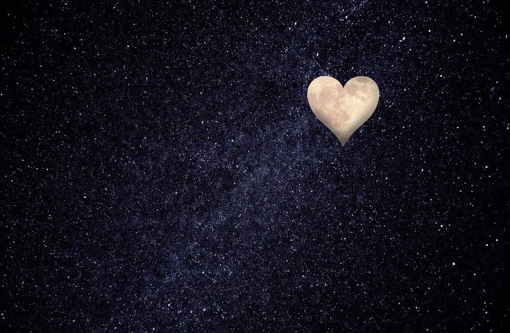 a heart shaped object floating in the air over a night sky filled with stars and dust