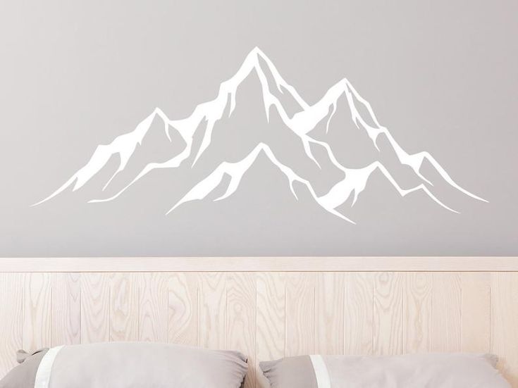 a white mountain wall decal above a bed