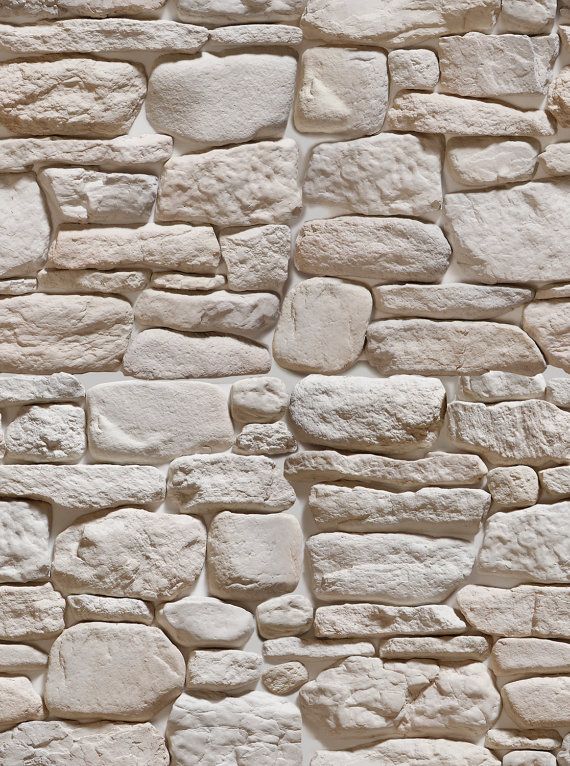 a white stone wall with some rocks on it