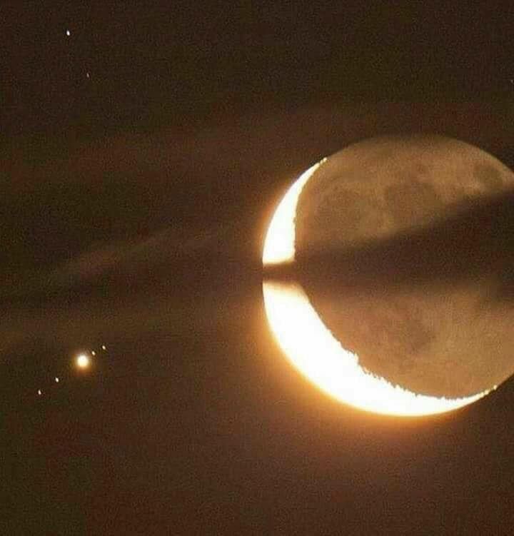 the moon is partially obscured by clouds as it passes through the sky