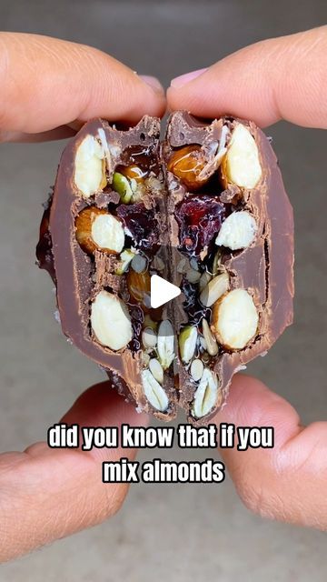 someone holding up a piece of chocolate with nuts and almonds on it that says did you know that if you mix almonds?