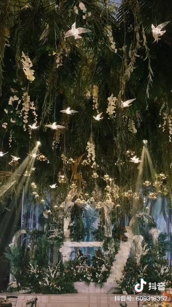 a room filled with lots of lights and plants hanging from the ceiling over it's head