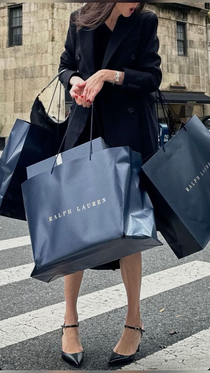 a woman is walking down the street carrying shopping bags