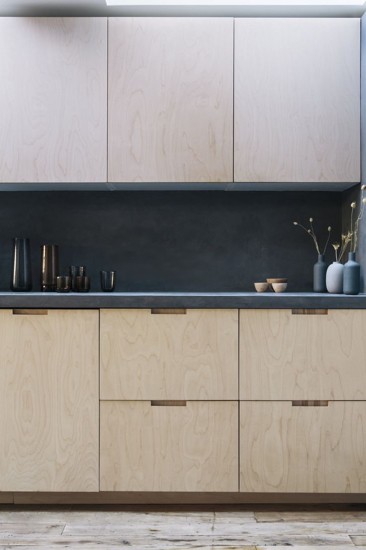 a kitchen with wooden cabinets and black counter tops, along with pots and vases